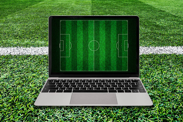Laptop σε πράσινη χλόη ποδόσφαιρο πεδίο φόντο. - Φωτογραφία, εικόνα