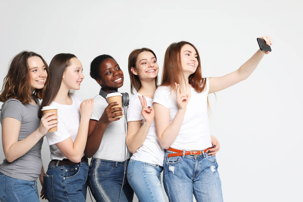 zdjęcie pięciu wieloetnicznych dziewczyn śmiejących się i robiących selfie  - Zdjęcie, obraz