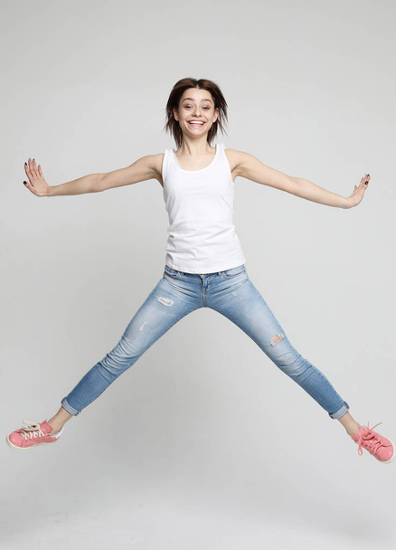 smiling young woman jumping in air over white  background  - Fotoğraf, Görsel