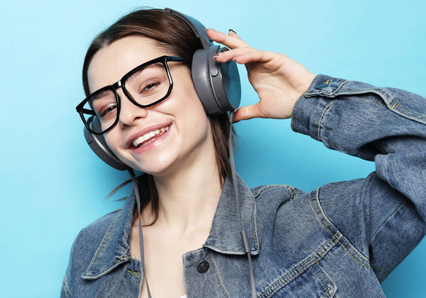 Beautiful young woman listening to music in headphones   - Zdjęcie, obraz