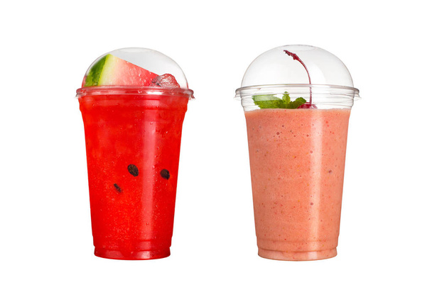 Delicious fruit smoothies in plastic cups, on a white background. Two cocktails with taste of a water-melon and with taste of cherry. Isolated - Photo, image