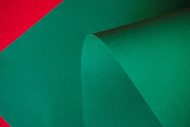 La feuille de papier vert vif sur un fond rouge. Conception de papier couleur monochrome
.    - Photo, image