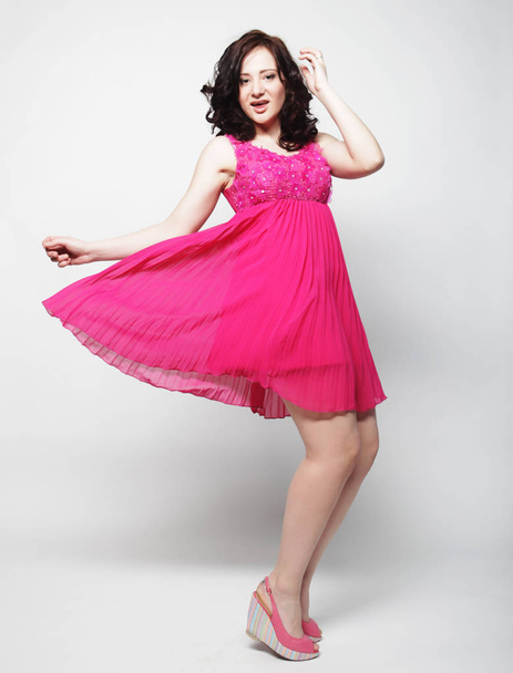 Full length portrait of happy beautiful woman in pink dress - 写真・画像