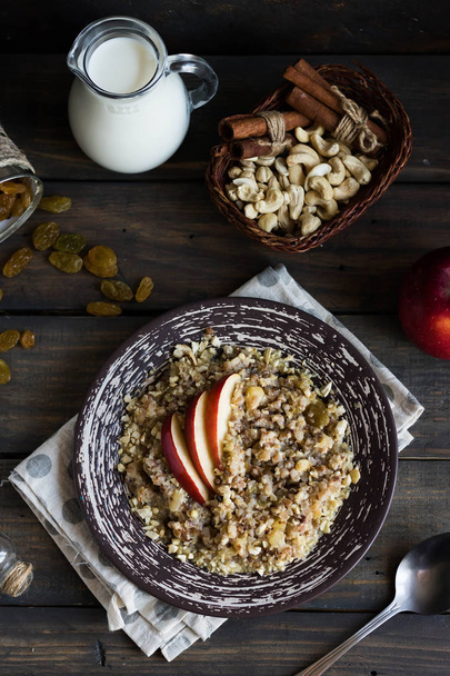 Buckwheat porridge with apples, raisins and cashew nuts for breakfast - Фото, изображение