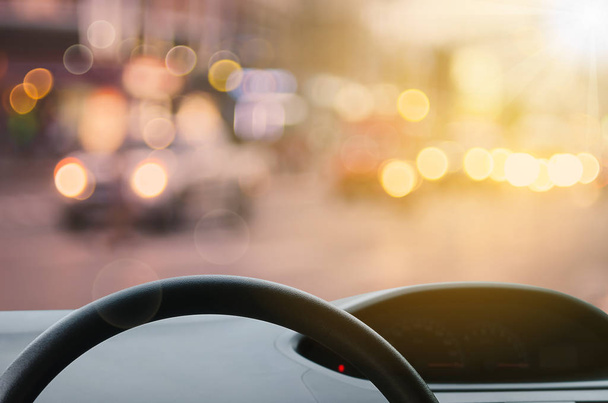 Inside car view ,steering wheel on blur traffic road with colorful bokeh light abstract background. Copy space of transportation and travel concept. Vintage tone filter effect color style. - Fotoğraf, Görsel