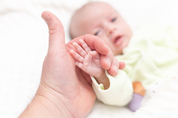 Ojciec trzymający rękę nowo narodzonego dziecka - Zdjęcie, obraz