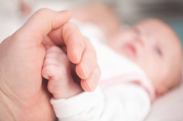 Father holding a hand of the newborn child - Photo, Image