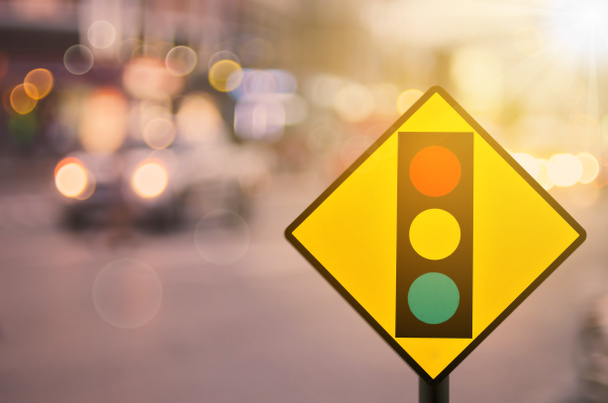 Segnale di avviso semaforo su strada traffico sfocato con sfondo colorato bokeh luce astratta
. - Foto, immagini
