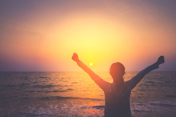 Copiar el espacio de la mujer levantarse mano en el cielo puesta del sol en la playa y el fondo de la isla
. - Foto, Imagen