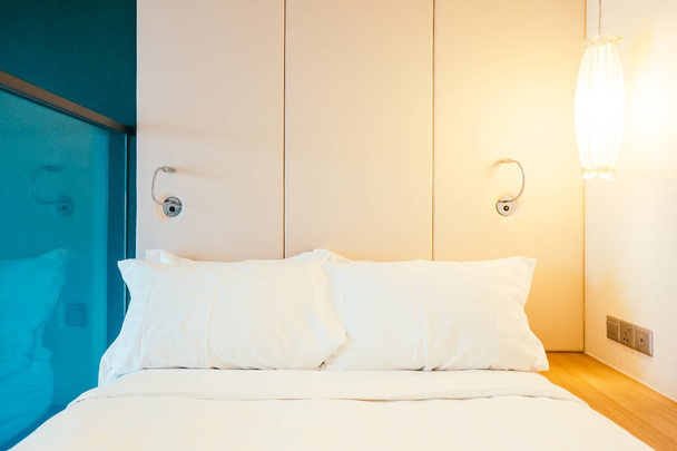 Біла зручна подушка на прикрасі ліжка в інтер'єрі готельного ліжка
 - Фото, зображення