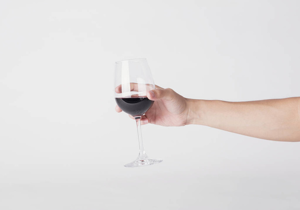 χέρι που κρατά ποτήρι κόκκινο κρασί σε λευκό φόντο. - Φωτογραφία, εικόνα
