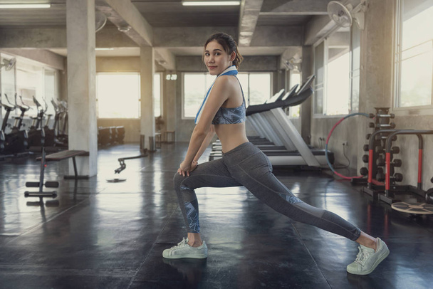 Молода азіатська усміхнена спортивна жінка стоїть розтягнуті м'язи
  - Фото, зображення