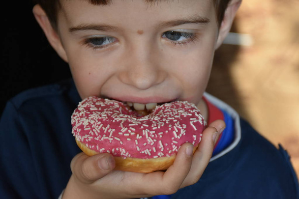 μικρό αγόρι τρώει ντόνατ  - Φωτογραφία, εικόνα