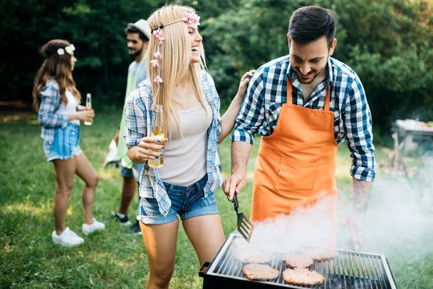 Cheerful friends spending time in nature and having barbecue - Foto, Imagem