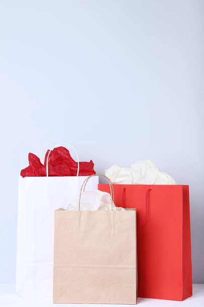 Colorful paper shopping bags on grey background - Foto, Bild