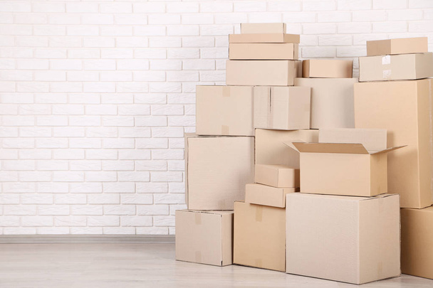 Cardboard boxes on brick wall background - Foto, imagen
