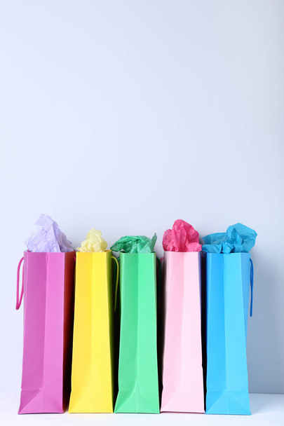 Colorful paper shopping bags on grey background - Фото, зображення