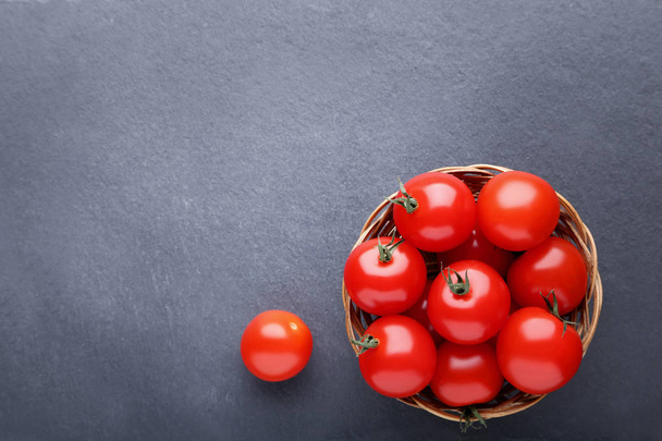 Cherry tomatoes in basket on black background - Foto, Bild