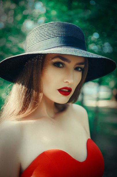 Gyönyörű hölgy egy szexi piros ruhában pózol - Fotó, kép