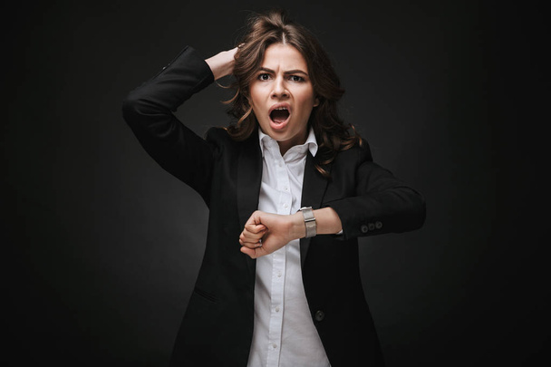 Shocked young businesswoman wearing a suit - Fotó, kép
