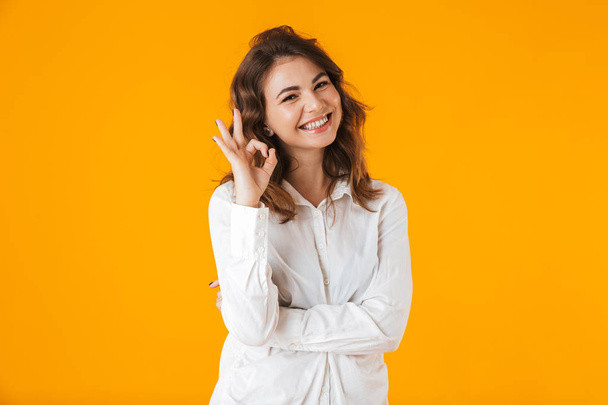 Portrait of a cheerful young woman wearing white shirt - Fotó, kép