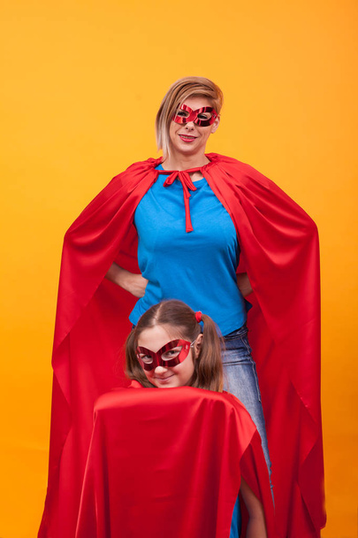 Anne ve kızı birlikte oynayan superheros gibi giyinmiş - Fotoğraf, Görsel