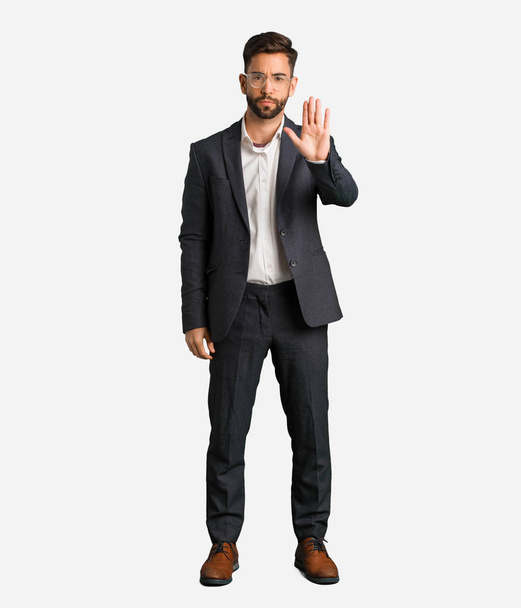 Joven hombre de negocios guapo poniendo la mano en frente
 - Foto, imagen