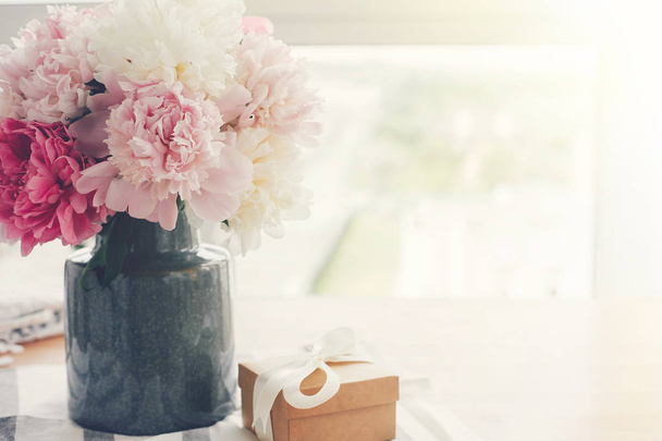 Стильные розовые и белые пионы в вазе и подарочной коробке с лентой
  - Фото, изображение