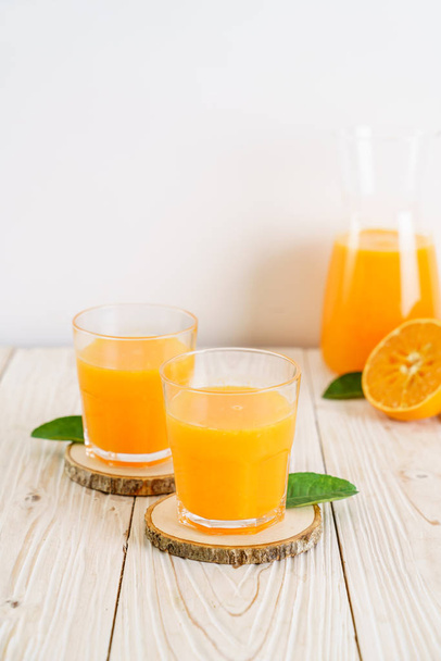 Fresh orange juice on wood background - Fotó, kép