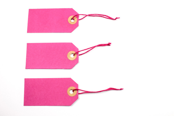 étiquettes en papier rose attachées avec des cordes isolées sur blanc
 - Photo, image