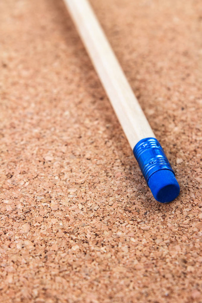 matita in legno con gomma blu su sfondo sughero
 - Foto, immagini