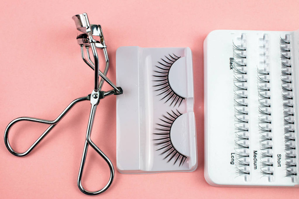Make-up zelfklevende lash fakkels en tools op roze achtergrond - Foto, afbeelding