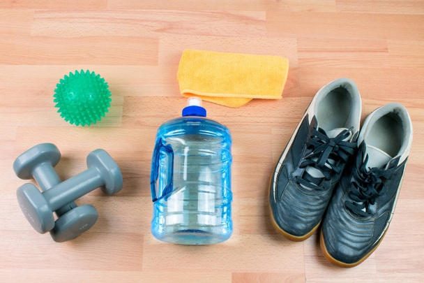 spor şişe, halter ve ahşap arka plan üzerinde ayakkabı - Fotoğraf, Görsel