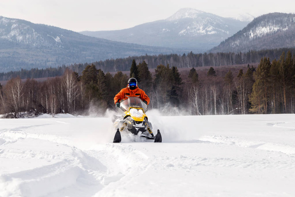 Atleta en una moto de nieve. - Foto, imagen