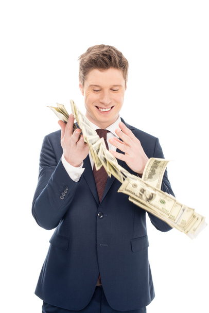 happy successful businessman throwing up dollar banknotes isolated on white - 写真・画像