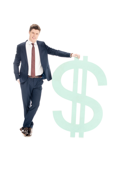 smiling young businessman posing with big dollar symbol isolated on white - Фото, изображение