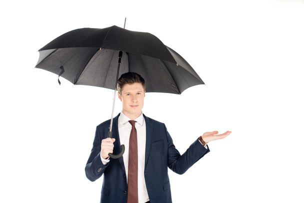 handsome businessman with umbrella checking rain, isolated on white - Фото, изображение