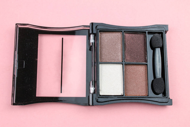 Paleta de sombras de maquillaje con pincel cosmético sobre fondo rosa
 - Foto, imagen