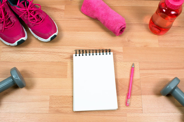 sport equipment and empty notepad on wooden background - Photo, Image