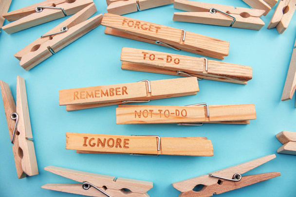 top view of wooden clothespins with different symbols on blue background - Photo, Image