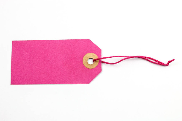 etiqueta de papel rosa atada con cuerda aislada en blanco
 - Foto, Imagen