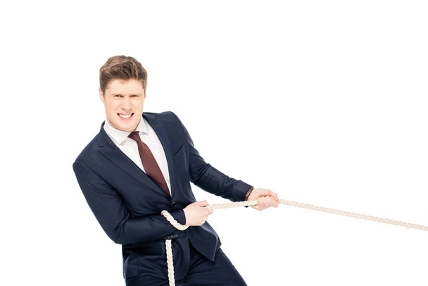 handsome young businessman in formal wear pulling rope isolated on white - Foto, afbeelding