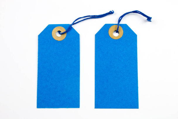 Etiquetas de papel azul amarradas com cordas isoladas em branco
 - Foto, Imagem