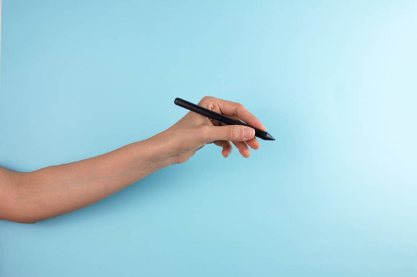 ritagliato colpo di penna mano femminile tenuta su sfondo blu
 - Foto, immagini
