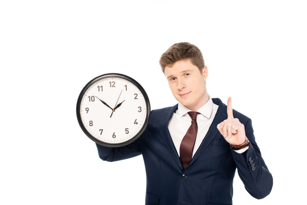 handsome businessman having idea and pointing up while holding clock isolated on white - Photo, Image