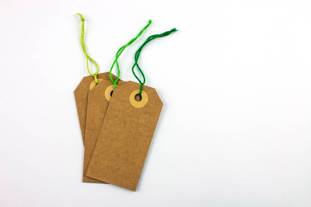 etiquetas de cartón atadas con cuerdas aisladas en blanco
 - Foto, imagen