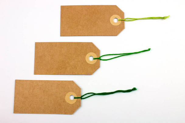 étiquettes en carton attachées avec des cordes isolées sur blanc
 - Photo, image
