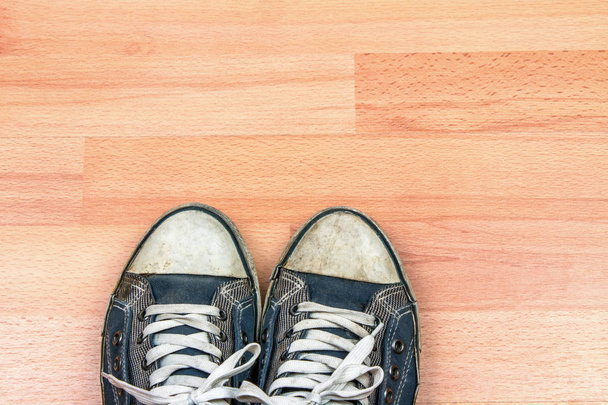 old sneakers on wooden floor background - Fotoğraf, Görsel
