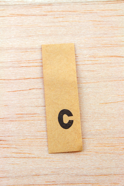 close-up shot of letter c on sticker attached on wooden surface - Photo, Image