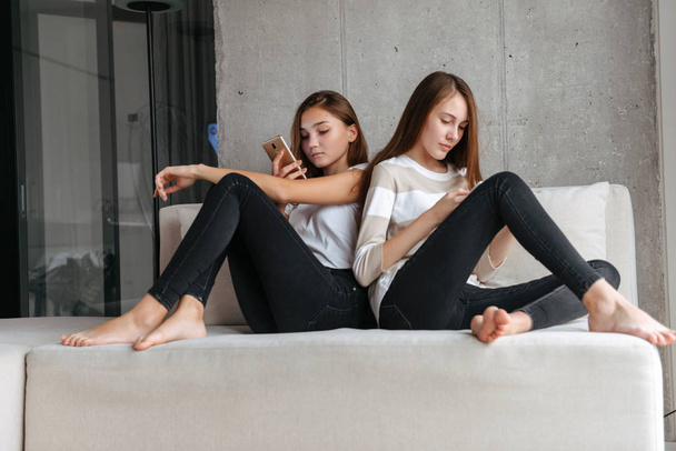 Two lovely young teenage girls using mobile phones - Fotoğraf, Görsel